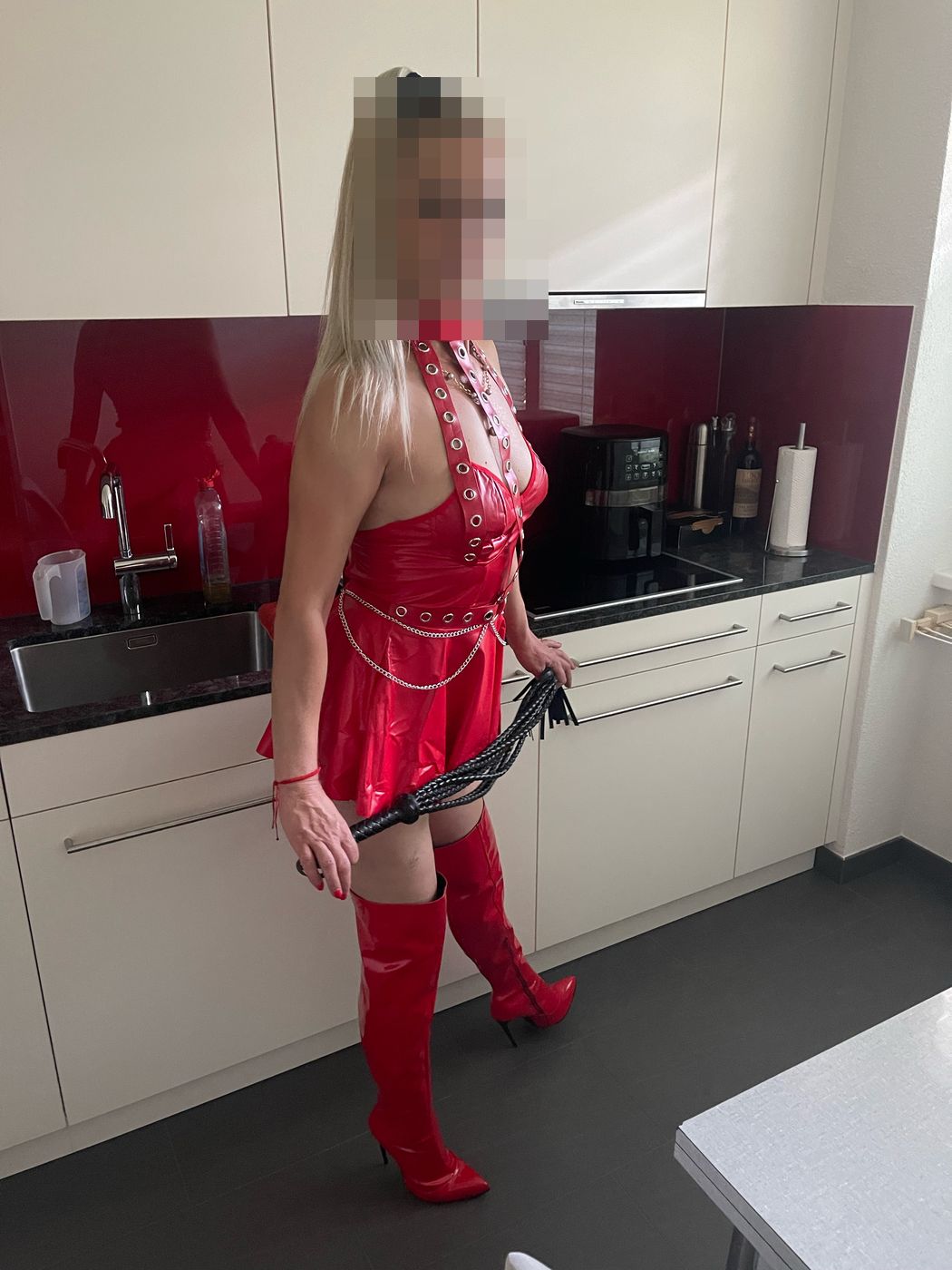 Lady Karla in rotem Lack mit Peitsche